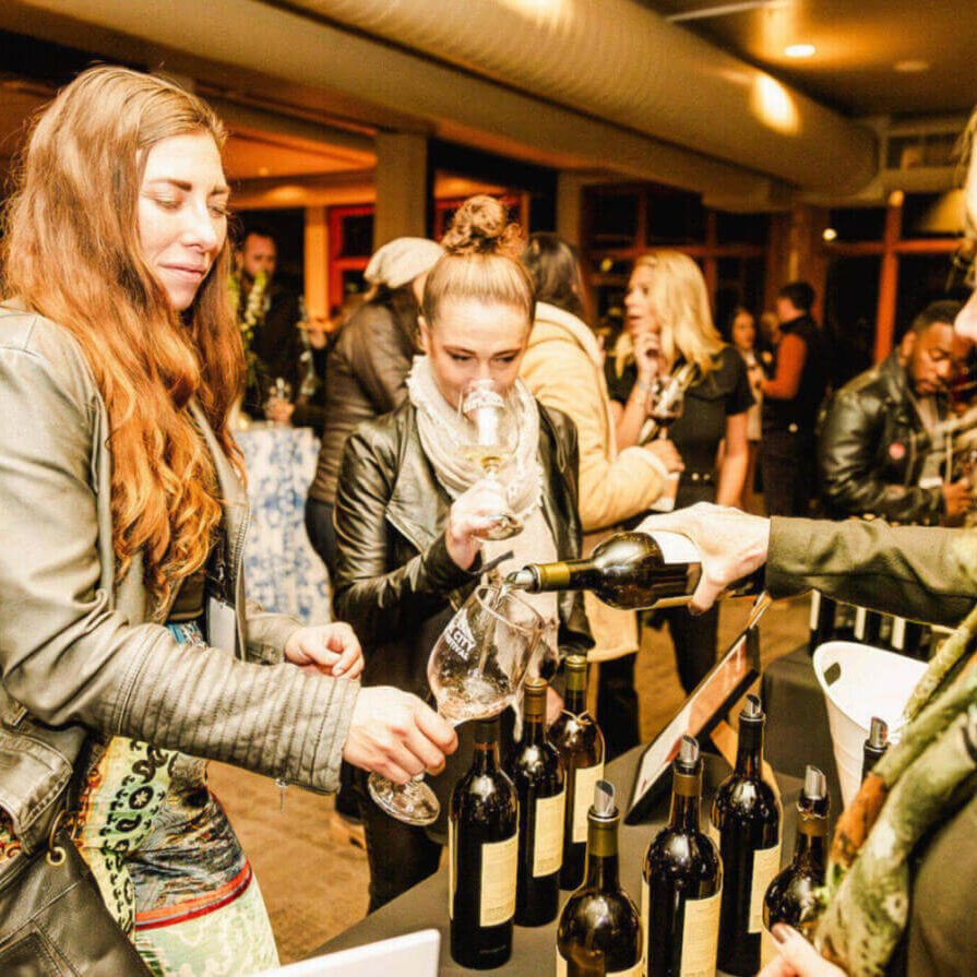 A group of friends clinking glasses of wine at the park city wine festival.