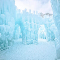 Families enjoying the midway ice castles walking through a tunnel of ice My local utah