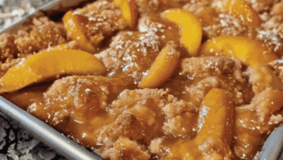 Old time oven peach cobbler freshly baked out the oven on a tray
