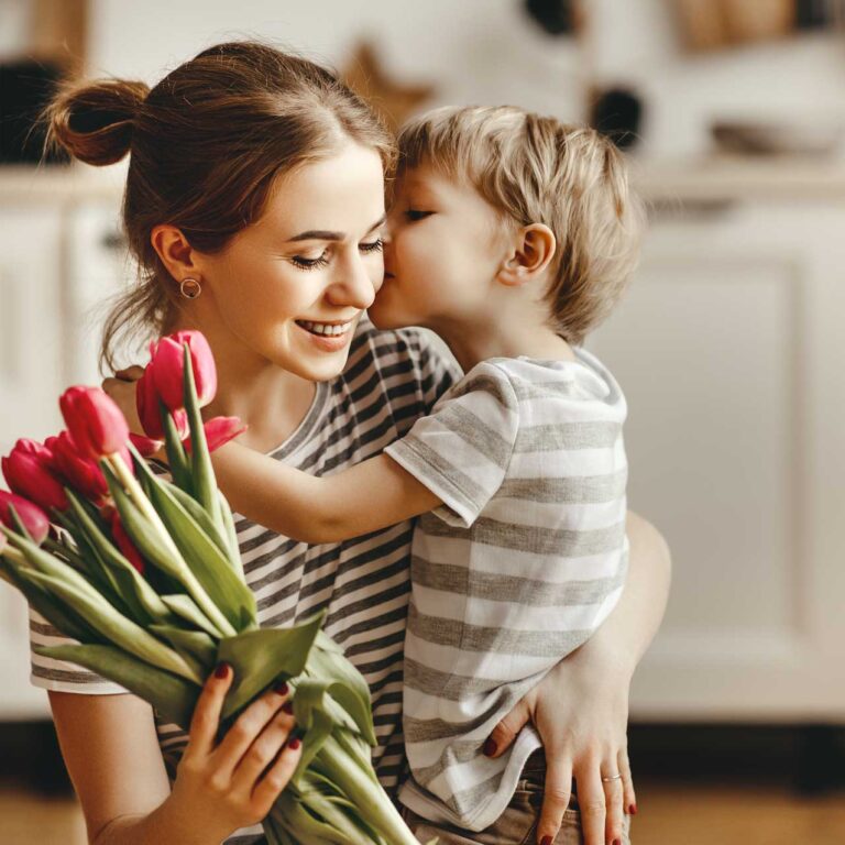 A mother and son enjoying mothers day brunch together with flowers.