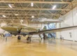 Inside a Hill Aerospace Museum gallery in Roy, Utah, with a C-47 Skytrain on the floor and a T-33 trainer suspended overhead